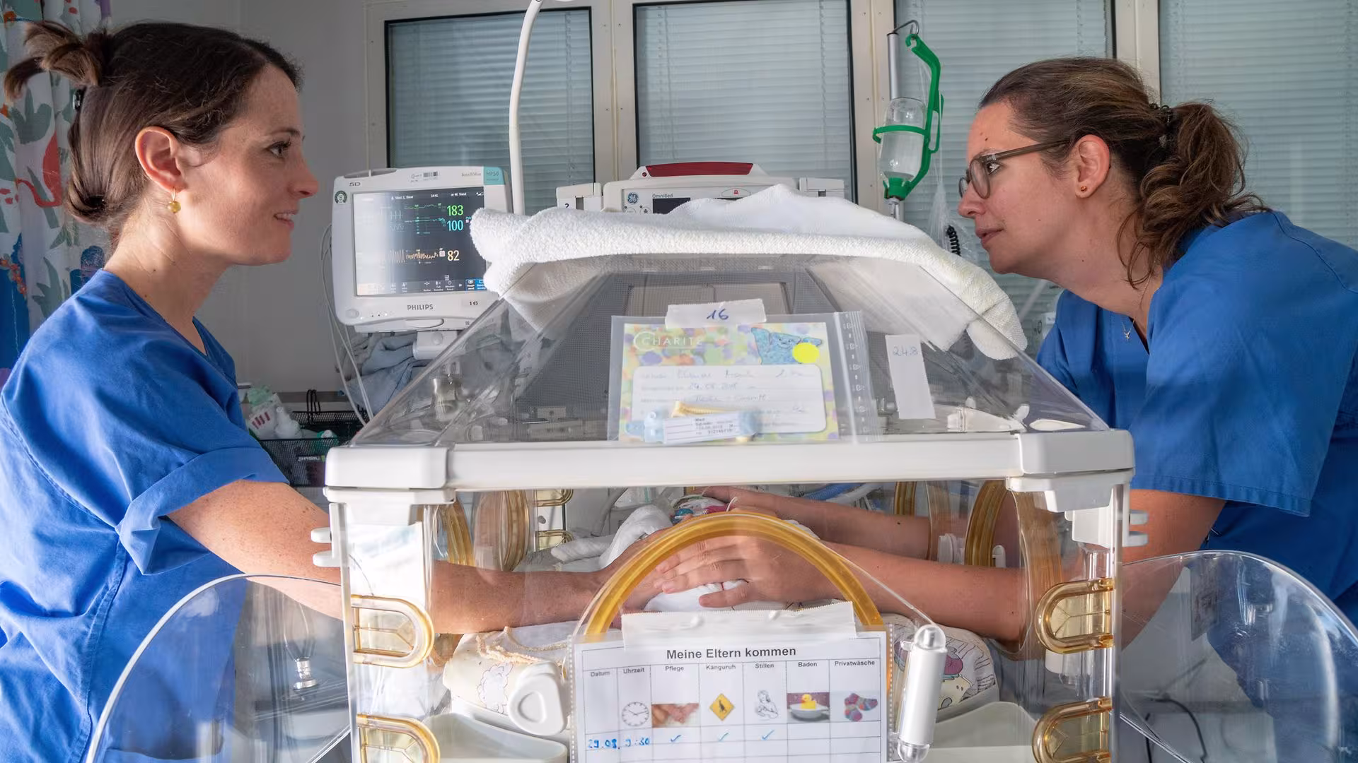 Fachkräfte der Charité – Universitätsmedizin Berlin kümmern sich um ein Neugeborenes in einem Inkubator.